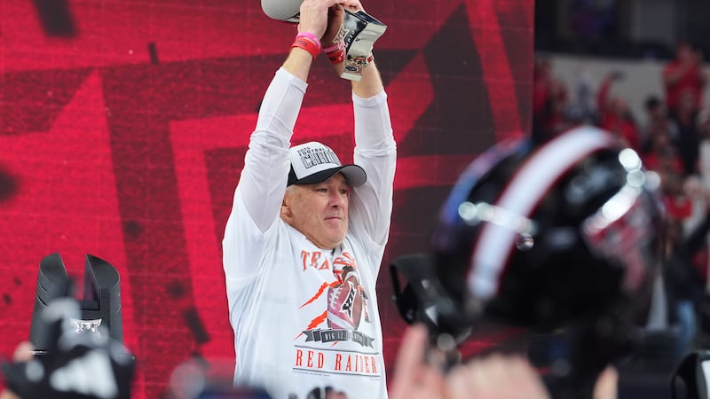 Texas Tech head coach Joey McGuire holds up the trophy after his team's win in the Big 12...
